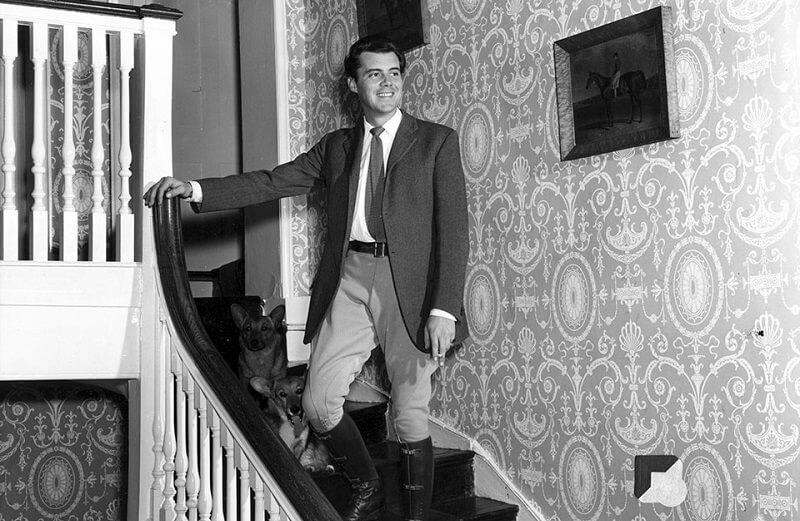 Dirk Bogarde and corgis on the staircase of Beel house, courtesy of Dirk Bogarde Estate