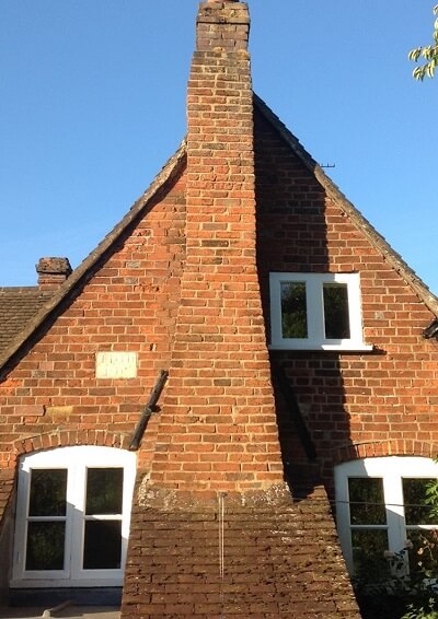The brick-facing to the rear of the Tudor house, with iron tie bars either side of the chimney and the ‘TDTD 1807’ plaque on the left.