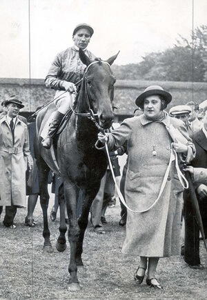 Dorothy Paget leading Straight Deal after winning the Derby in 1943, in one of her “shapeless tweed coats