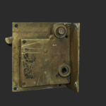 An old, rectangular brass lock mechanism with visible screws, a latch, and two circular holes, shown against a plain dark background. The surface is worn and scratched, indicating age and use.